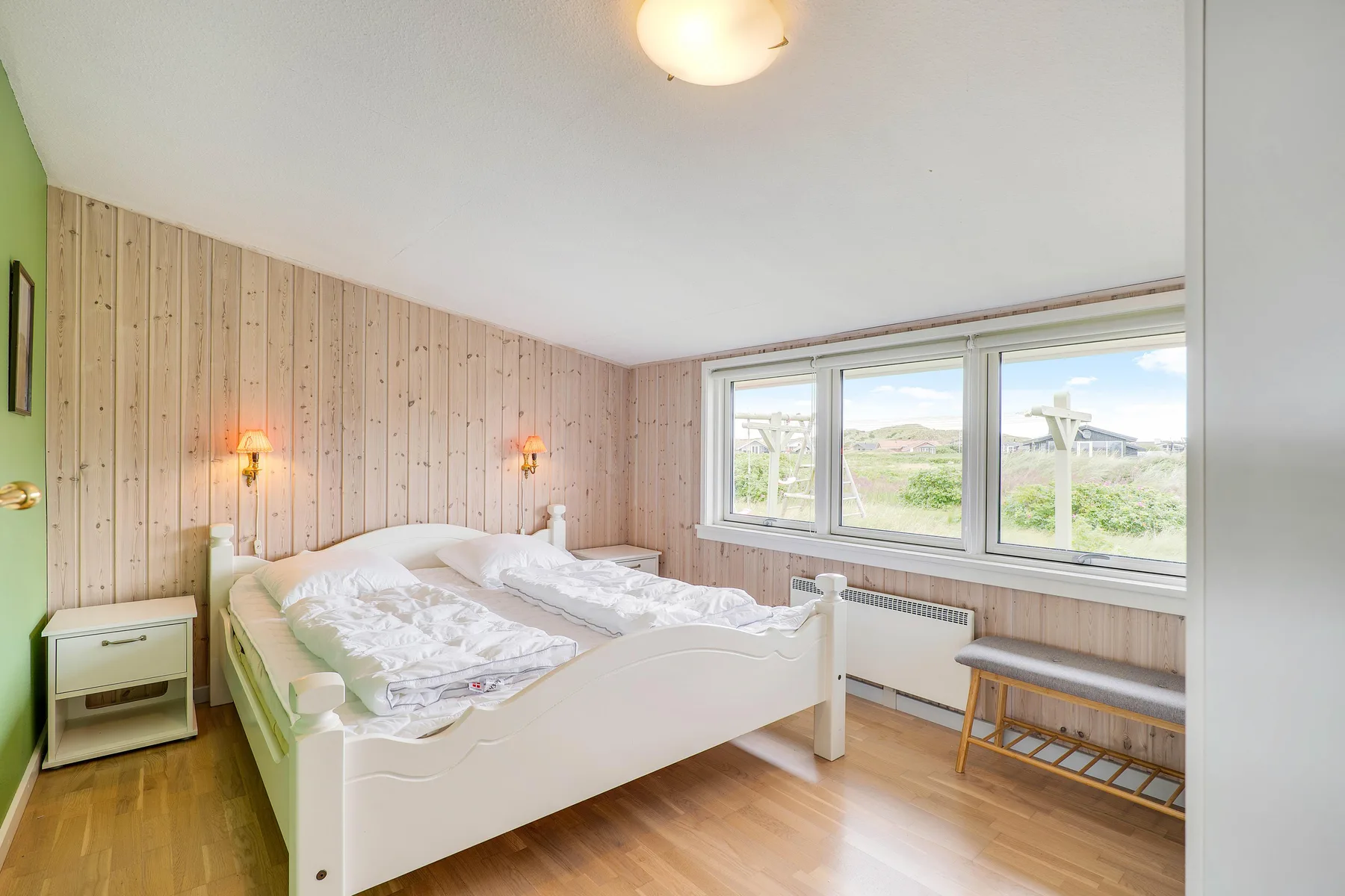 Un dormitorio con dos camas y ventanas amplias con vistas al paisaje.