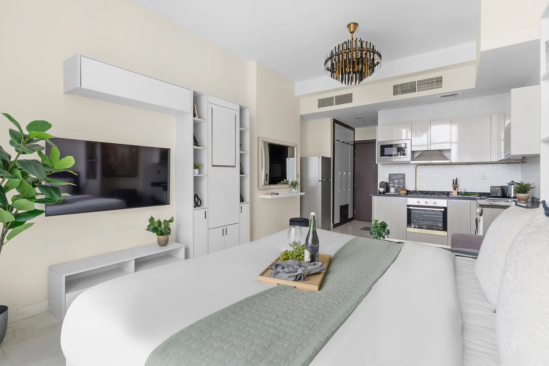 Una luminosa sala de estar se abre a una cocina moderna, con un televisor montado en la pared.