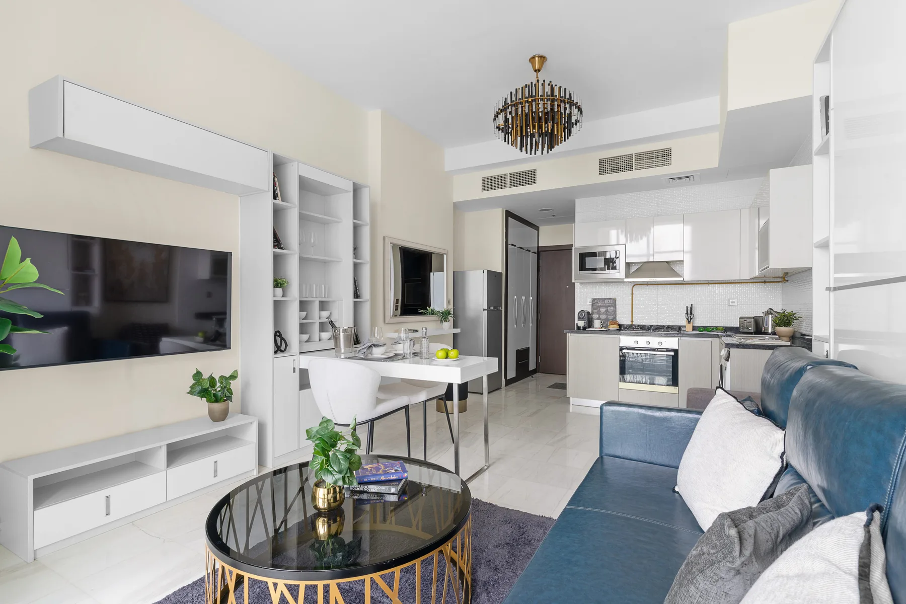 Una luminosa sala de estar y cocina de concepto abierto, con mesa de comedor y asientos azules.