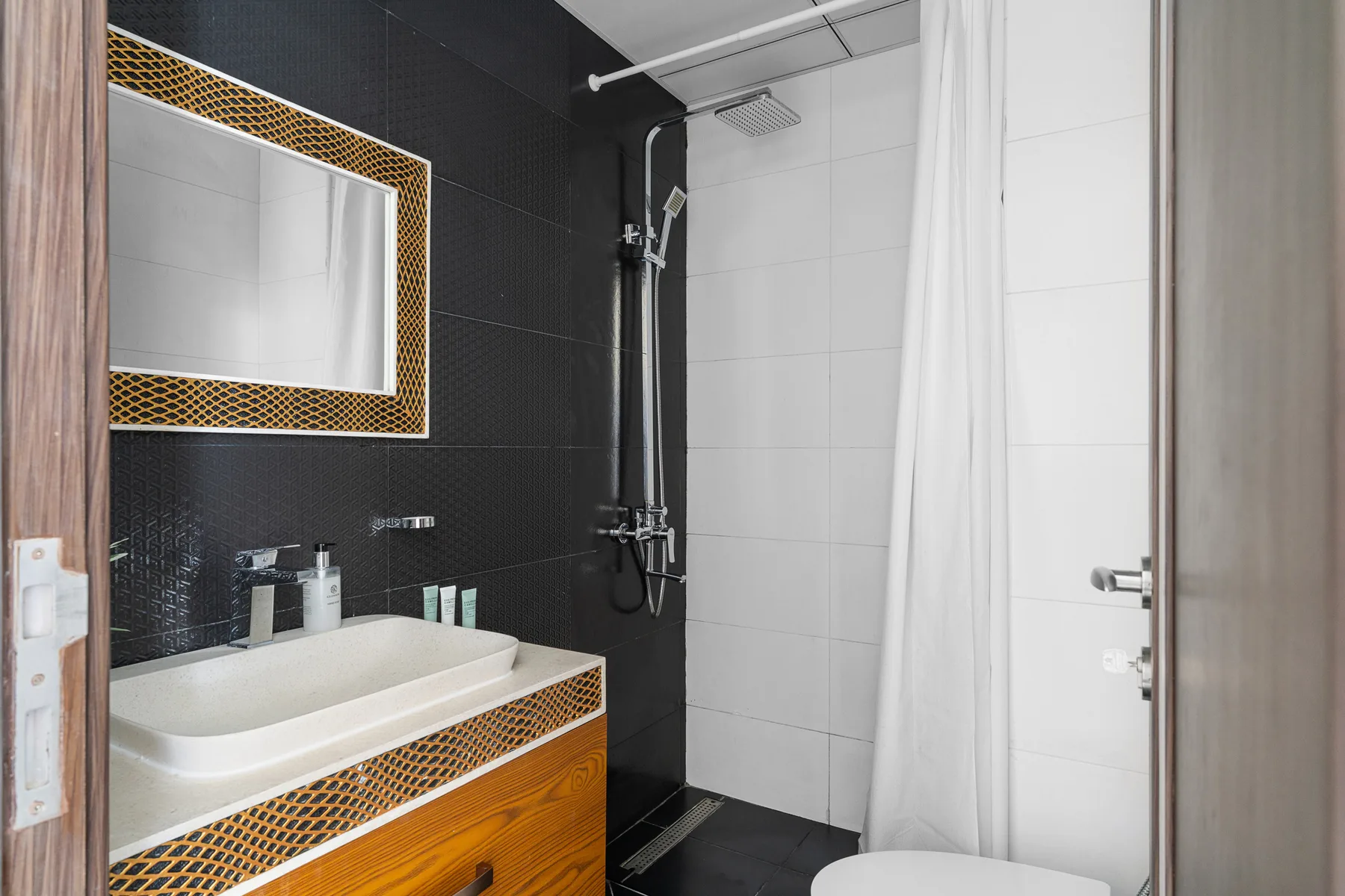 Un baño con lavabo, espejo y ducha.