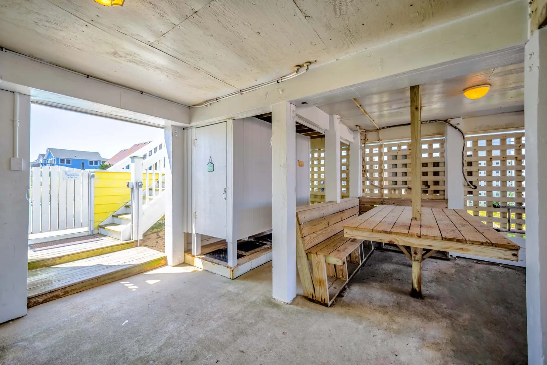 A covered outdoor seating area with wooden benches and a table.