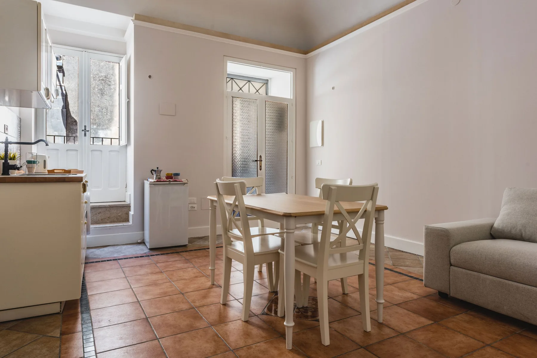 Un comedor luminoso con una mesa y sillas junto a una puerta de vidrio.