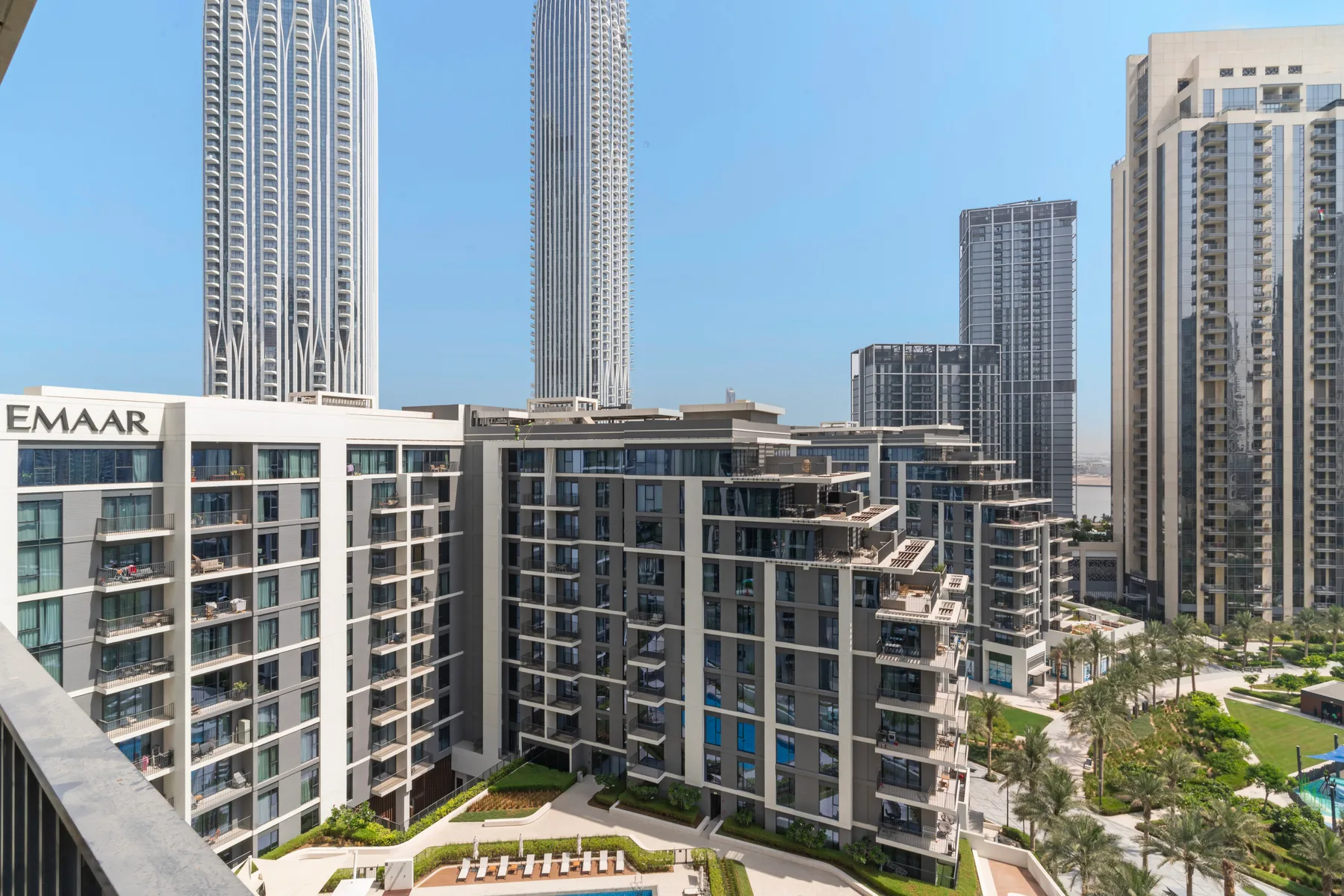 Un paisaje urbano de edificios modernos rodea un patio ajardinado.