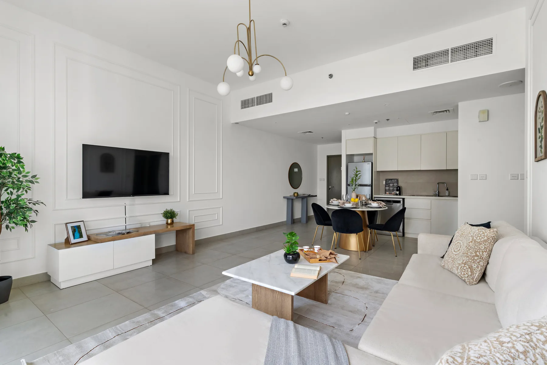 Una sala luminosa se abre a un comedor y una cocina moderna.