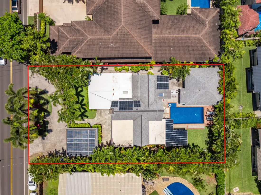 Vista aérea de una casa con piscina y jardines alrededor.