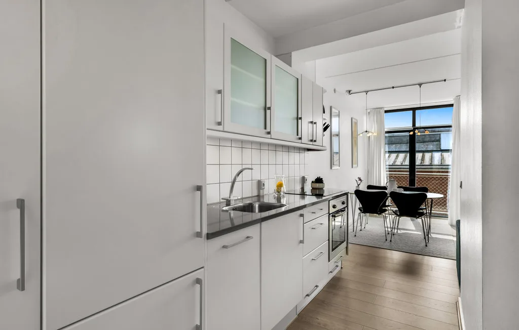 Una cocina luminosa da a un comedor junto a una ventana amplia.