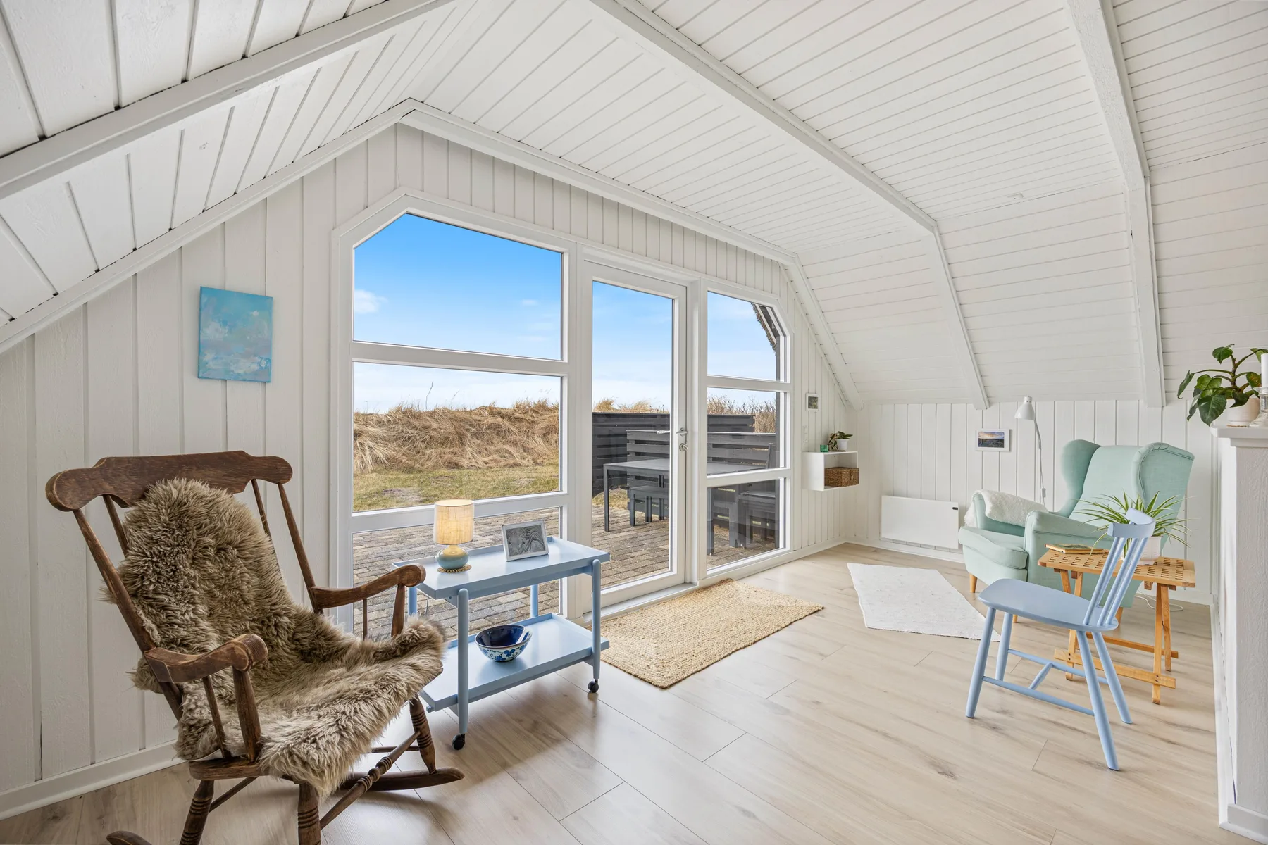 A bright sitting room with large windows and a seating area.