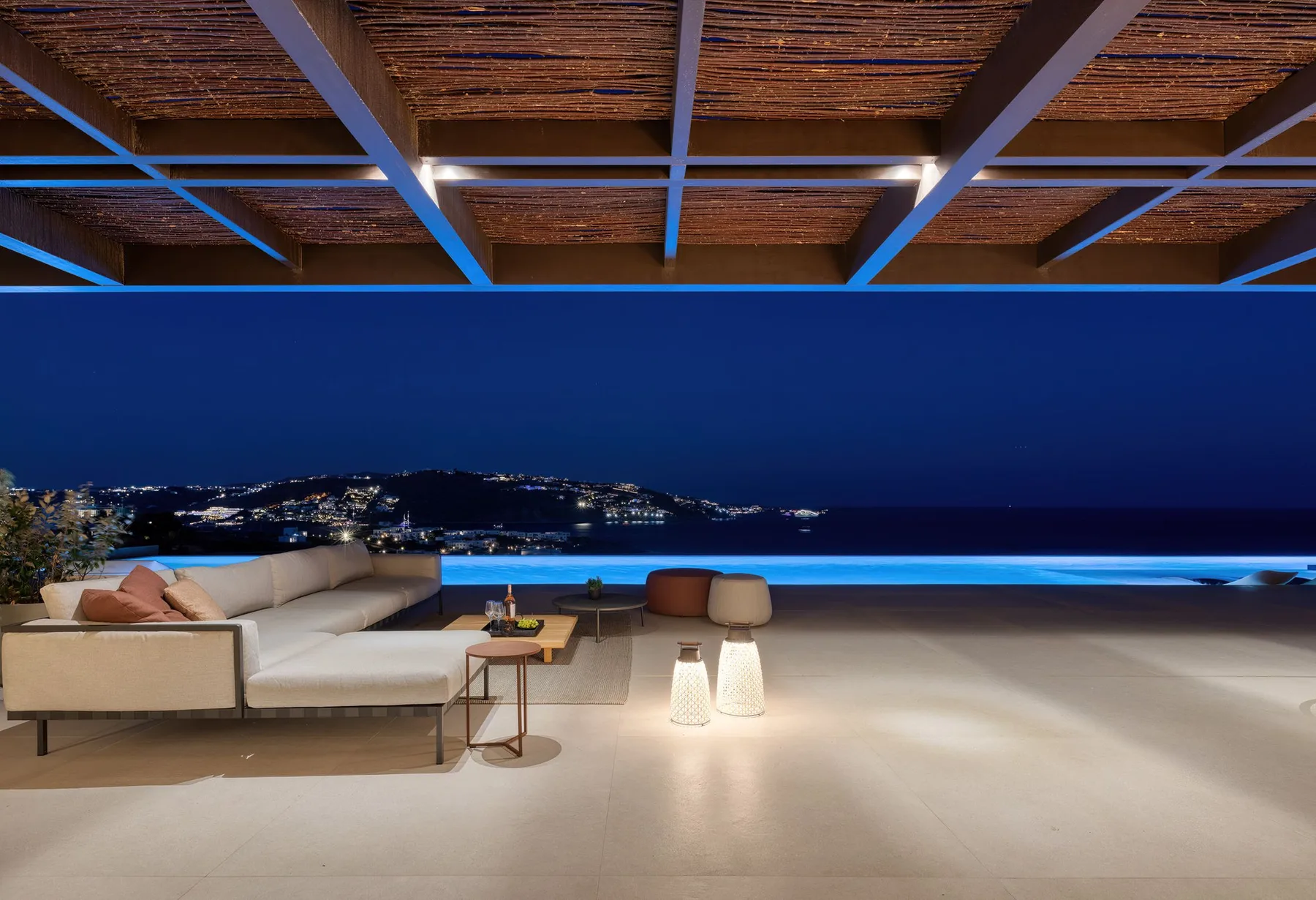 Una sala al aire libre con asientos y vistas costeras de noche.