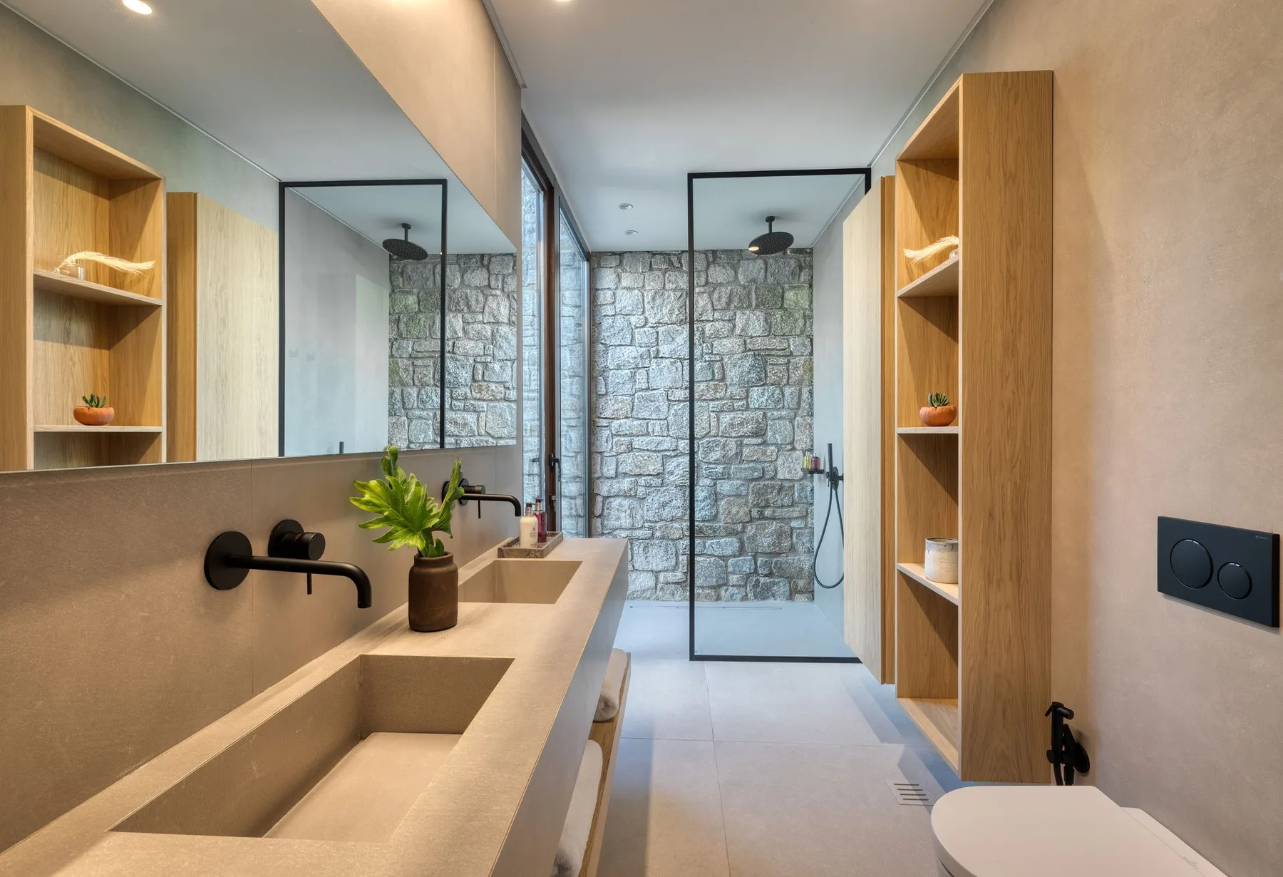 Un baño moderno con un lavabo largo y una ducha a ras de suelo.
