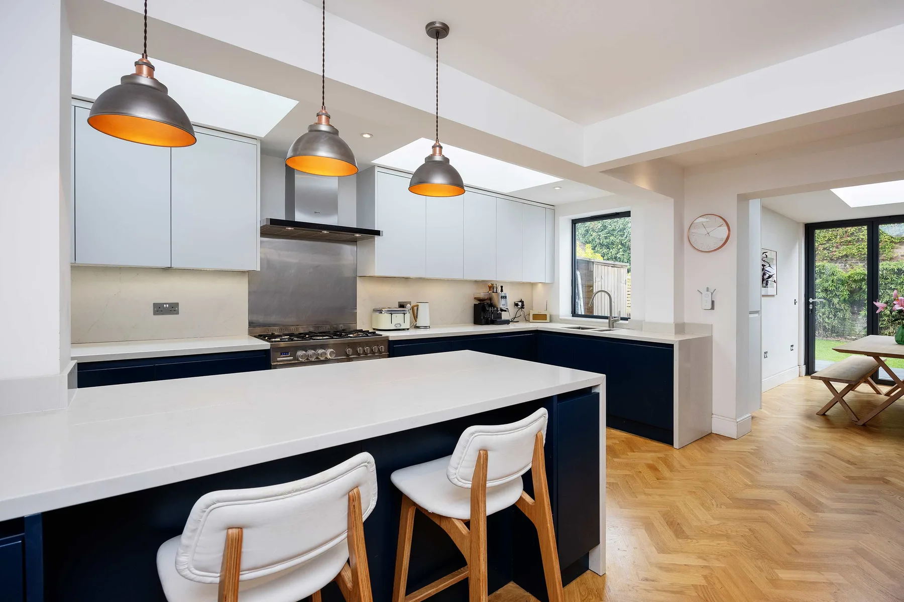A bright kitchen with a long island, pendant lights, and adjoining dining space.