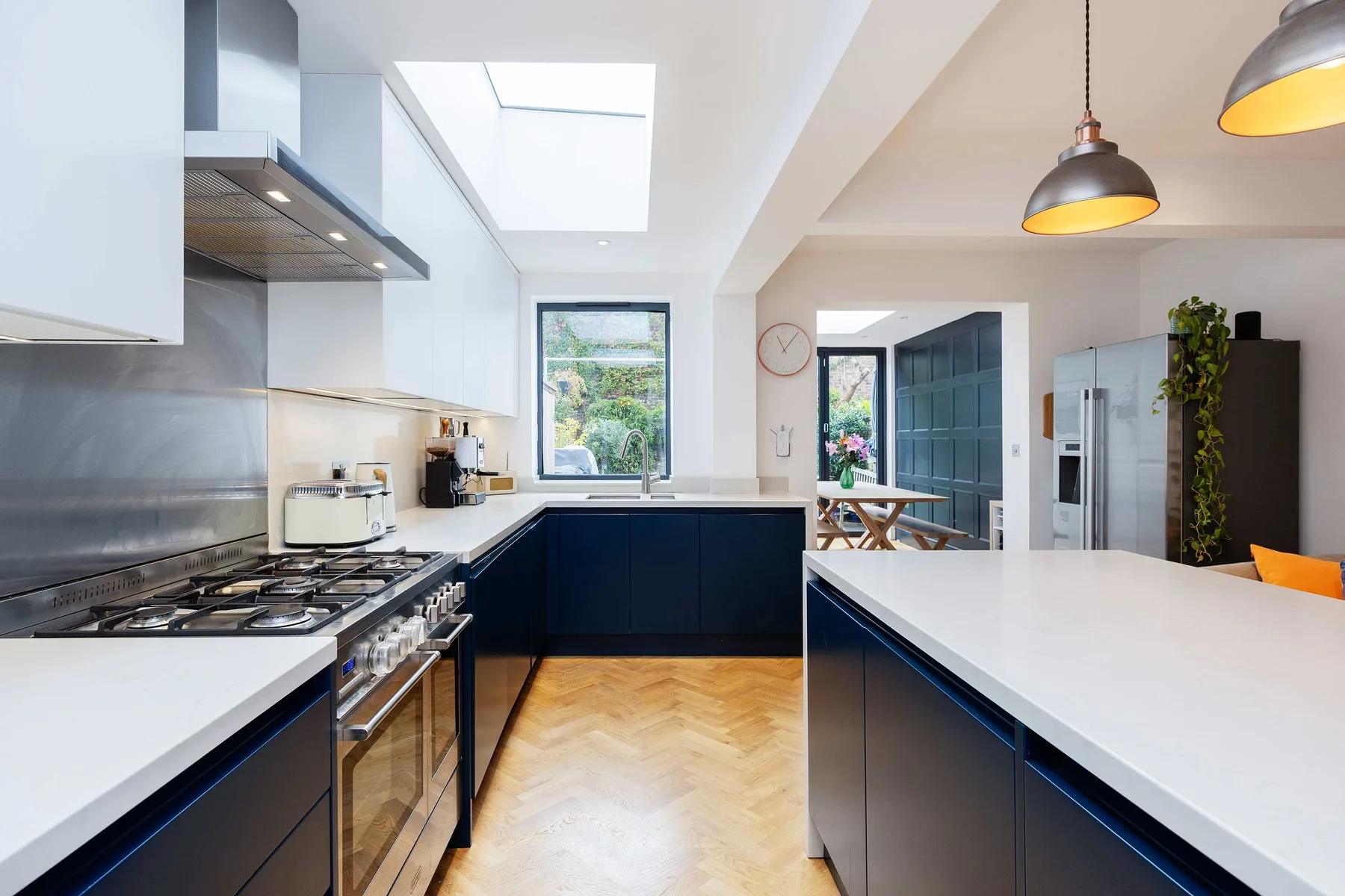 A bright modern kitchen with dark cabinetry and a large white island.