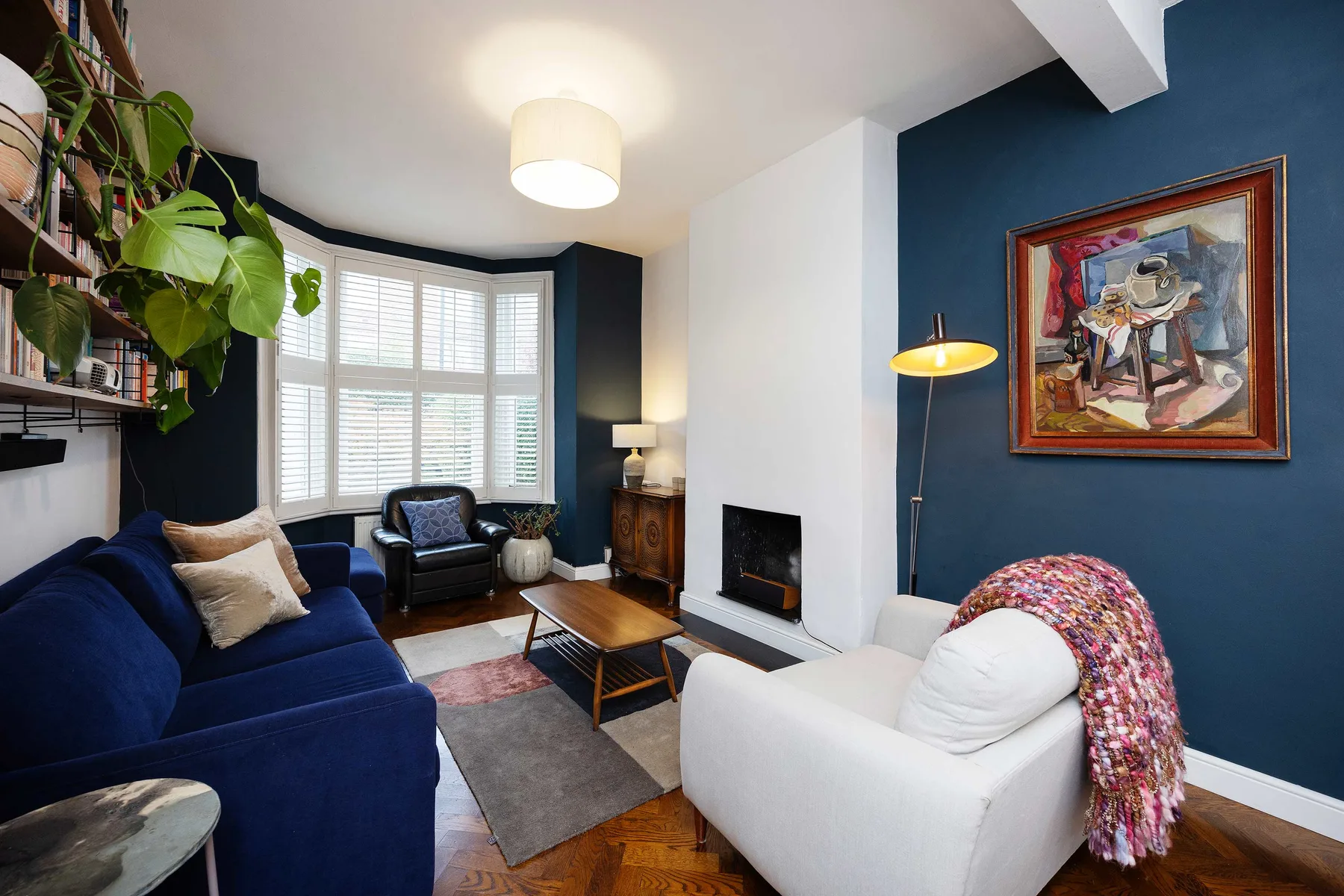 A living room with seating arranged around a fireplace and a large window.