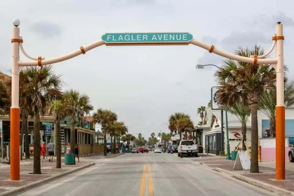 A palm-lined street runs beneath an arch marked Flagler Avenue.