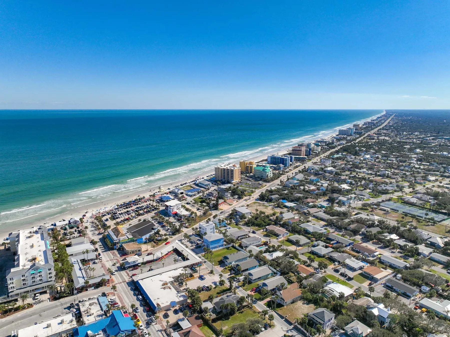 Aerial view of a coastal city with a long beach and ocean shoreline.