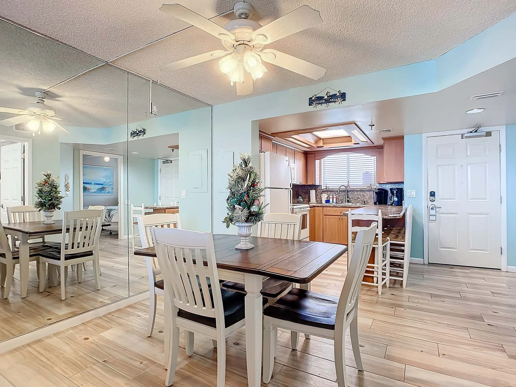A dining area with a wooden table and chairs beside an open kitchen.