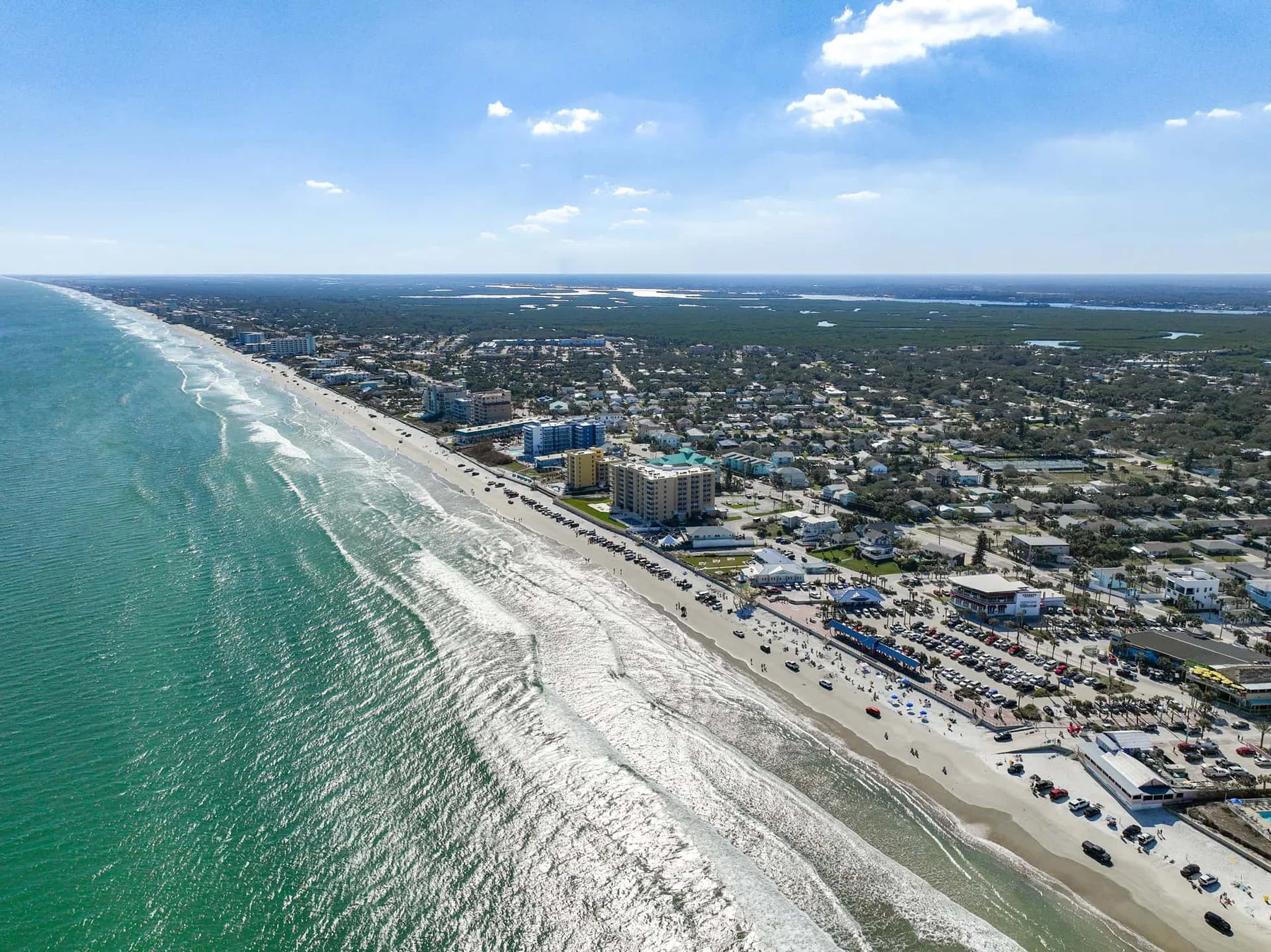 Aerial view of a coastal town along a sandy beach and ocean.