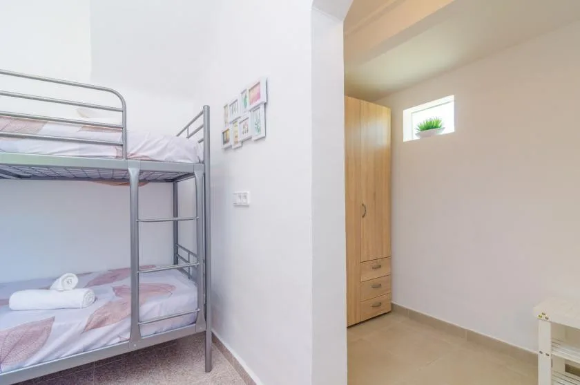 Un dormitorio con literas junto a un pequeño espacio y un armario de madera.