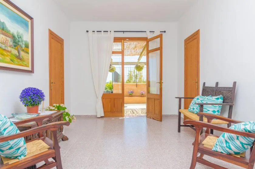 Una luminosa sala de estar se abre al balcón a través de puertas de madera.