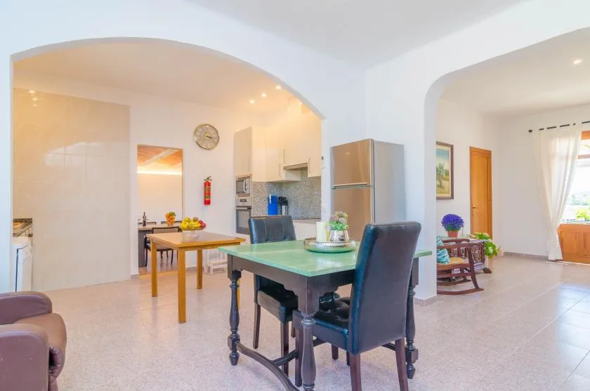 Un comedor abierto junto a la cocina, con una mesa al lado de la zona de cocina.