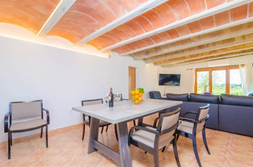 Comedor con una mesa y asientos junto a una zona de estar.