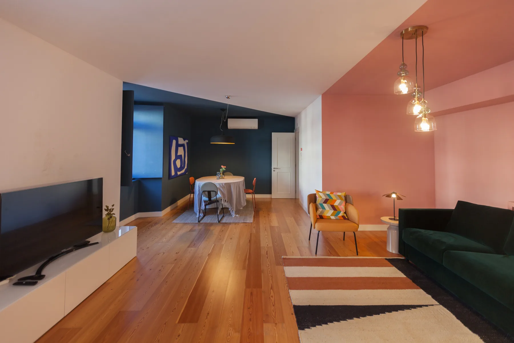 Open-plan living and dining room with a television, table, and seating.