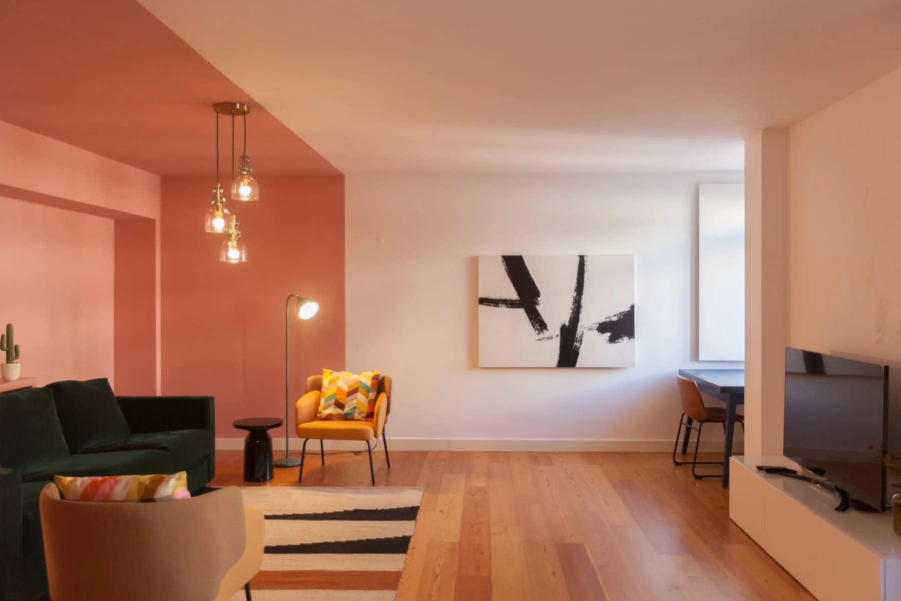 Living room with seating, a television, and abstract wall art.