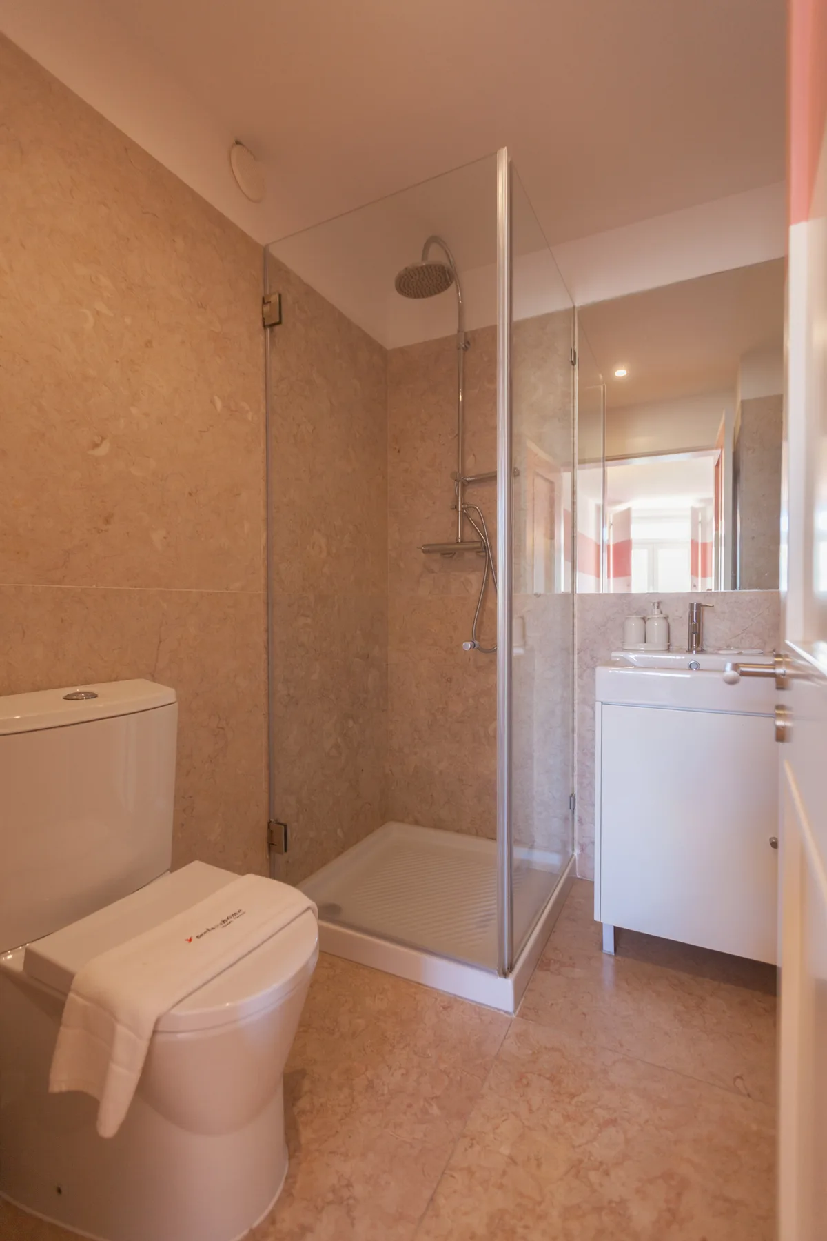 A bathroom with a shower, toilet, and sink.
