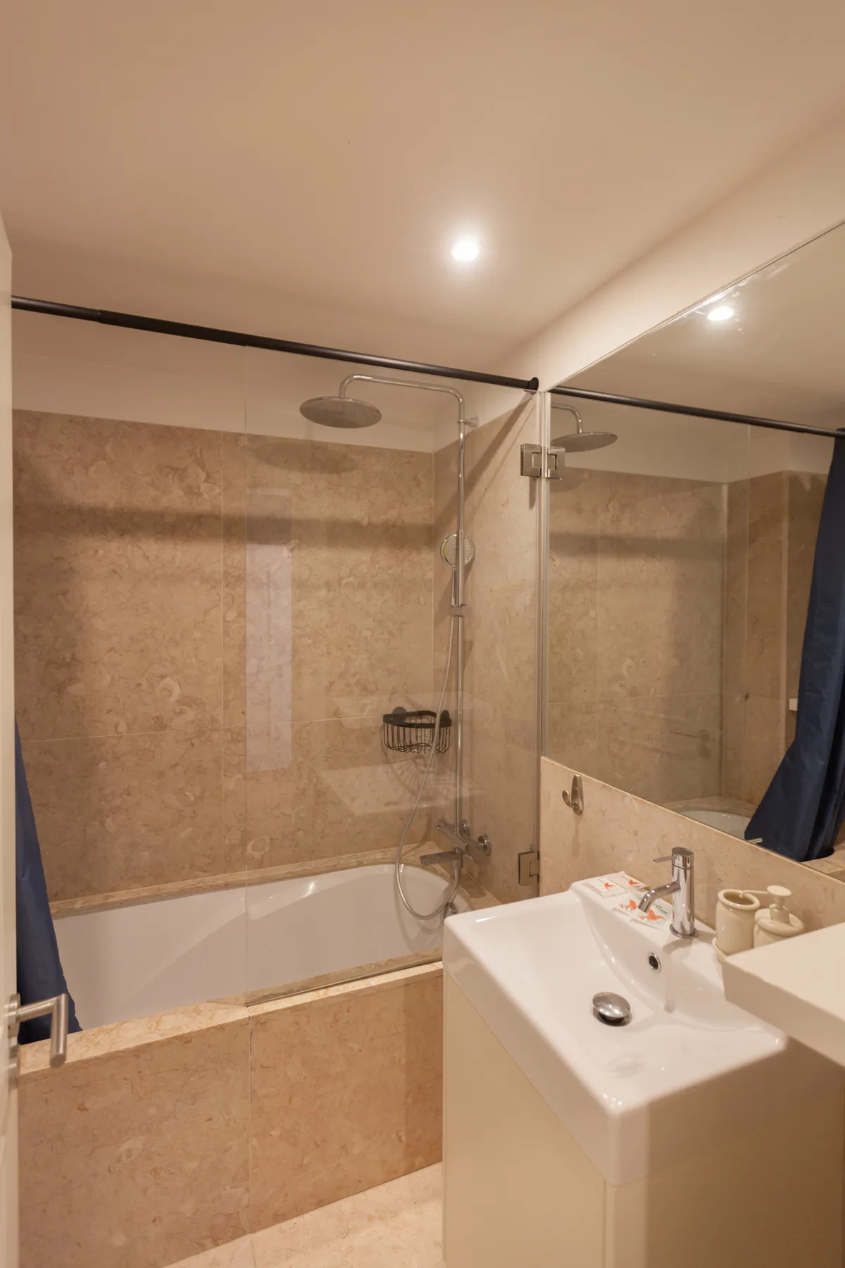 A bathroom with a bathtub, shower, and sink.