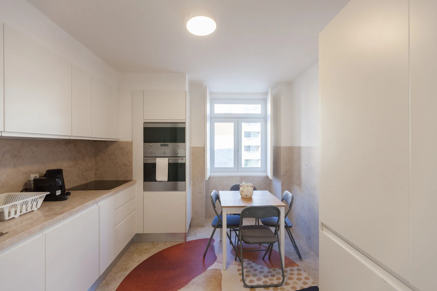 A bright kitchen and dining area with a table beside the window.
