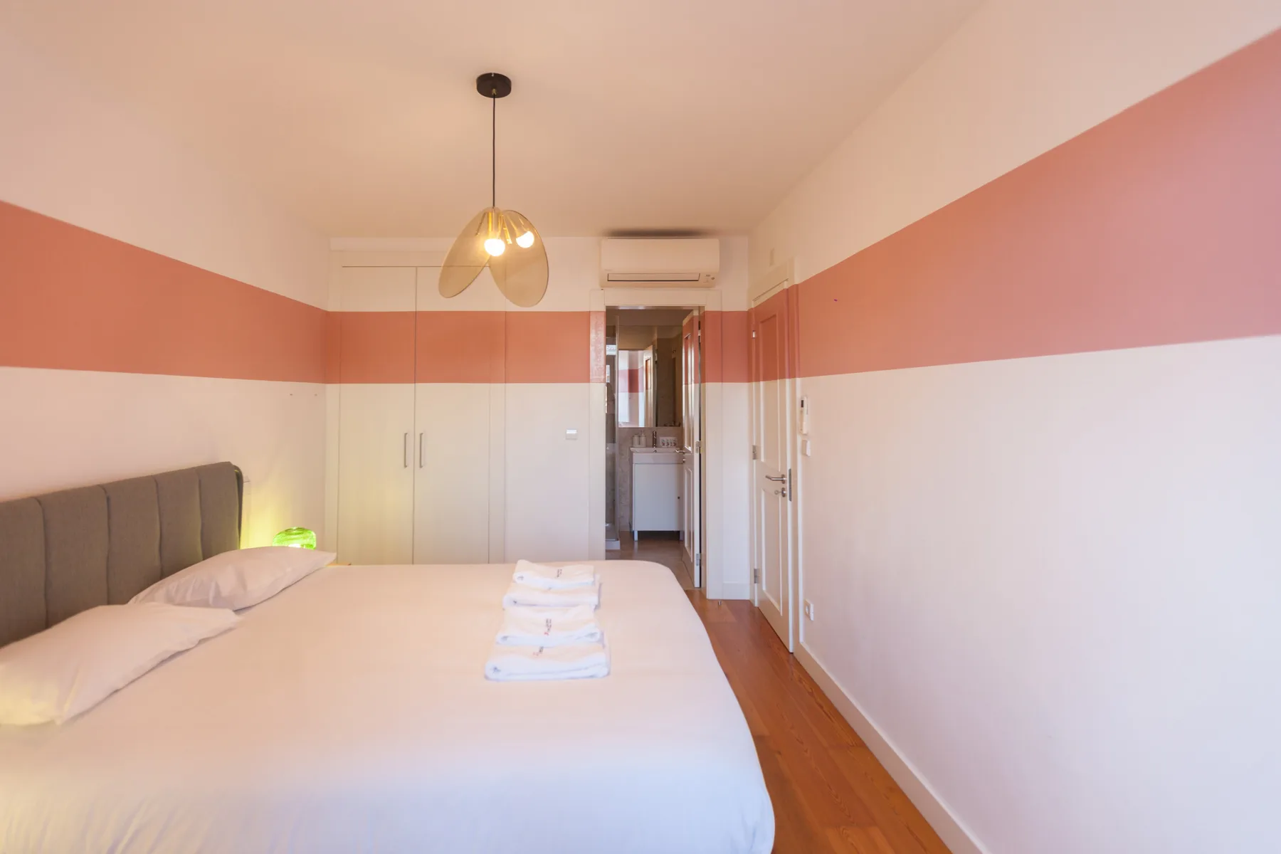 A bedroom with a bed, built-in storage, and a doorway to the adjoining space.