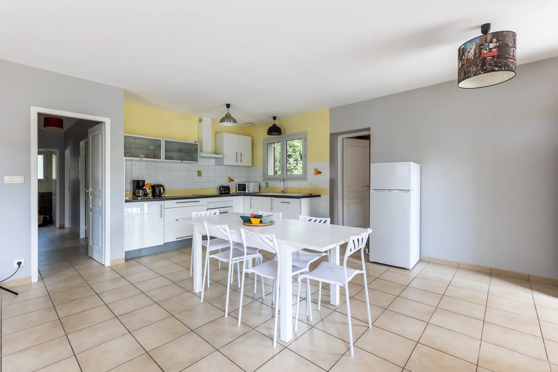 A bright kitchen and dining area with white cabinets and a table.