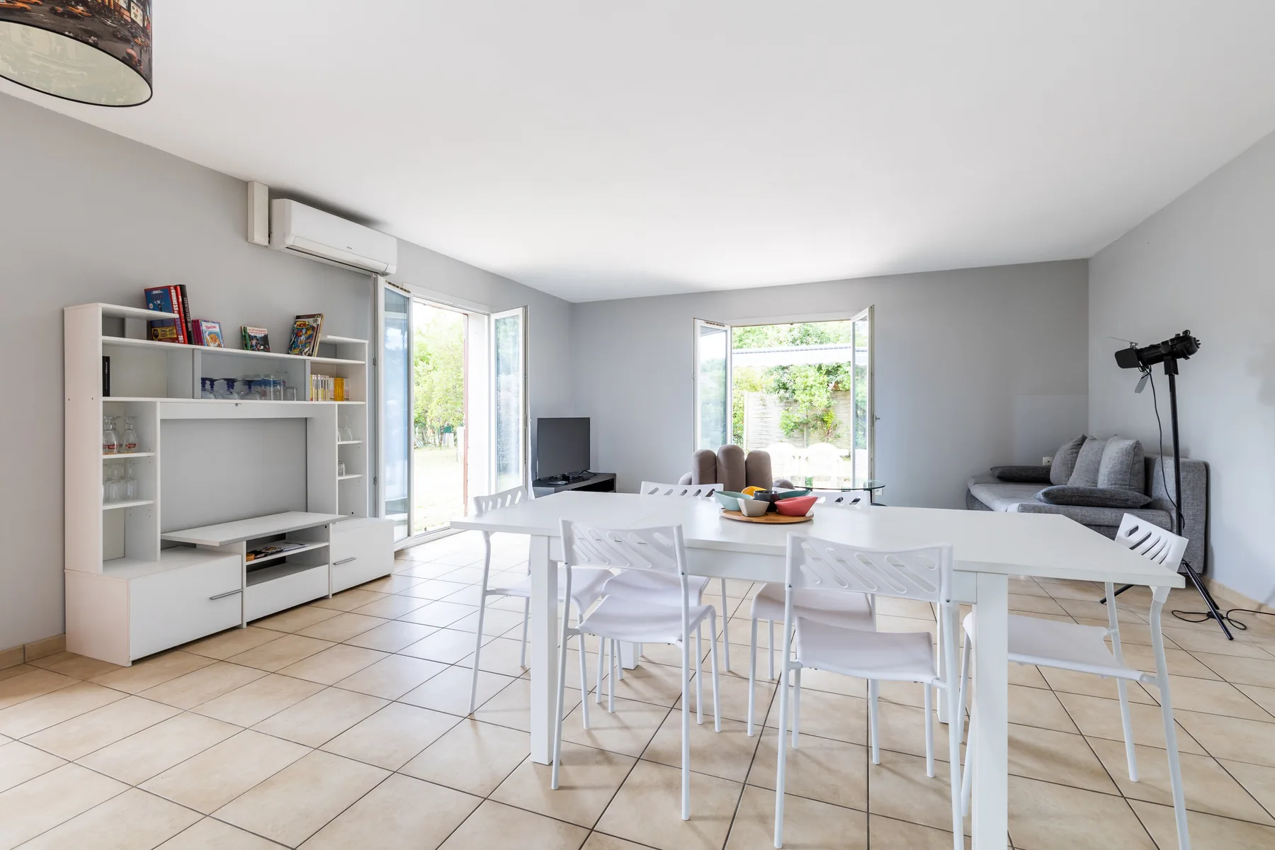 A bright living and dining area with a long table and seating.