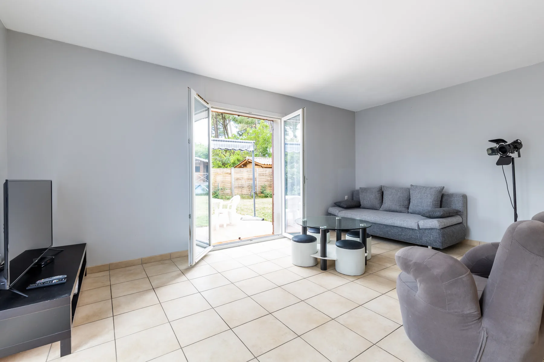 Living room with seating and open glass doors leading to a patio.