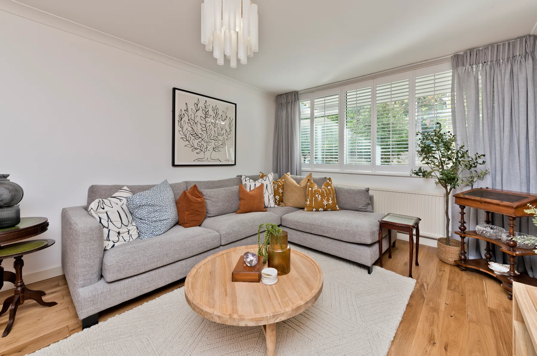 Living room with a sectional seating area beside wide windows.