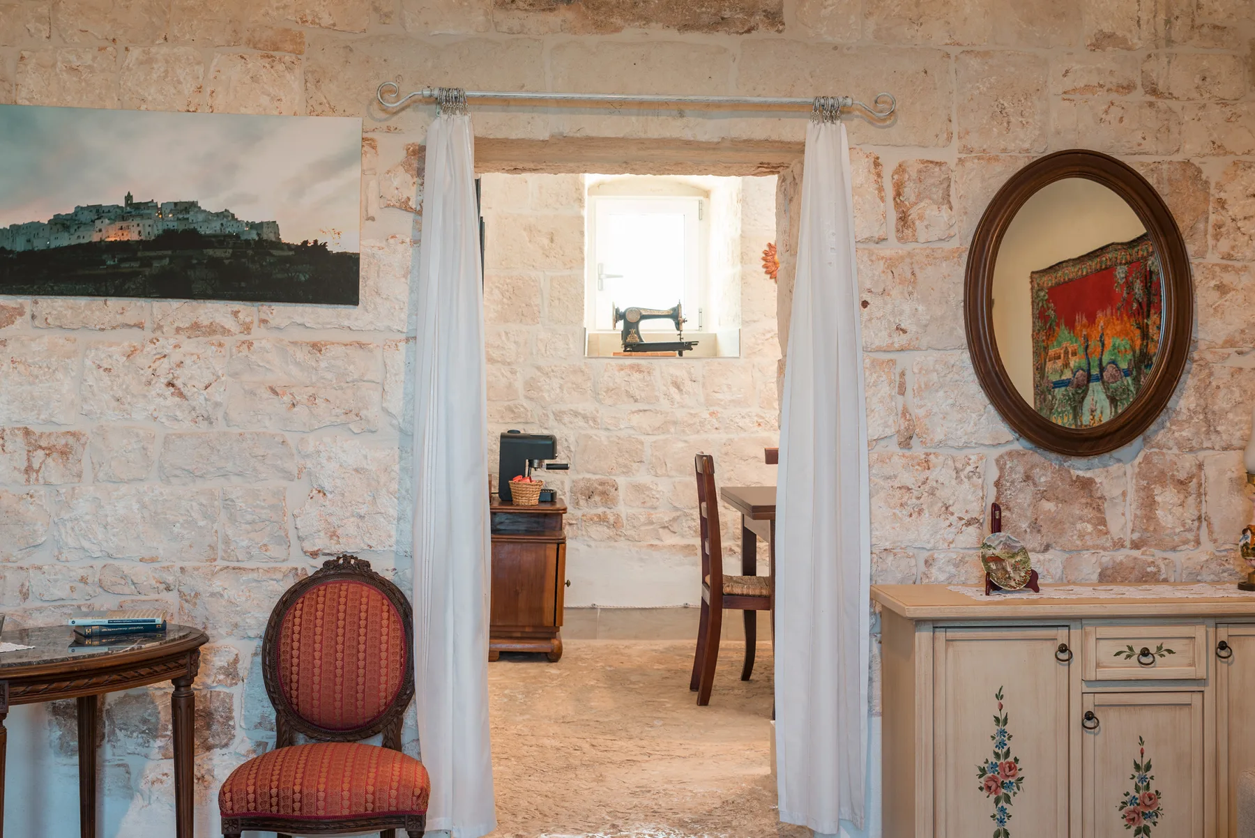 A rustic dining area with a wooden table, chairs, and stone walls.