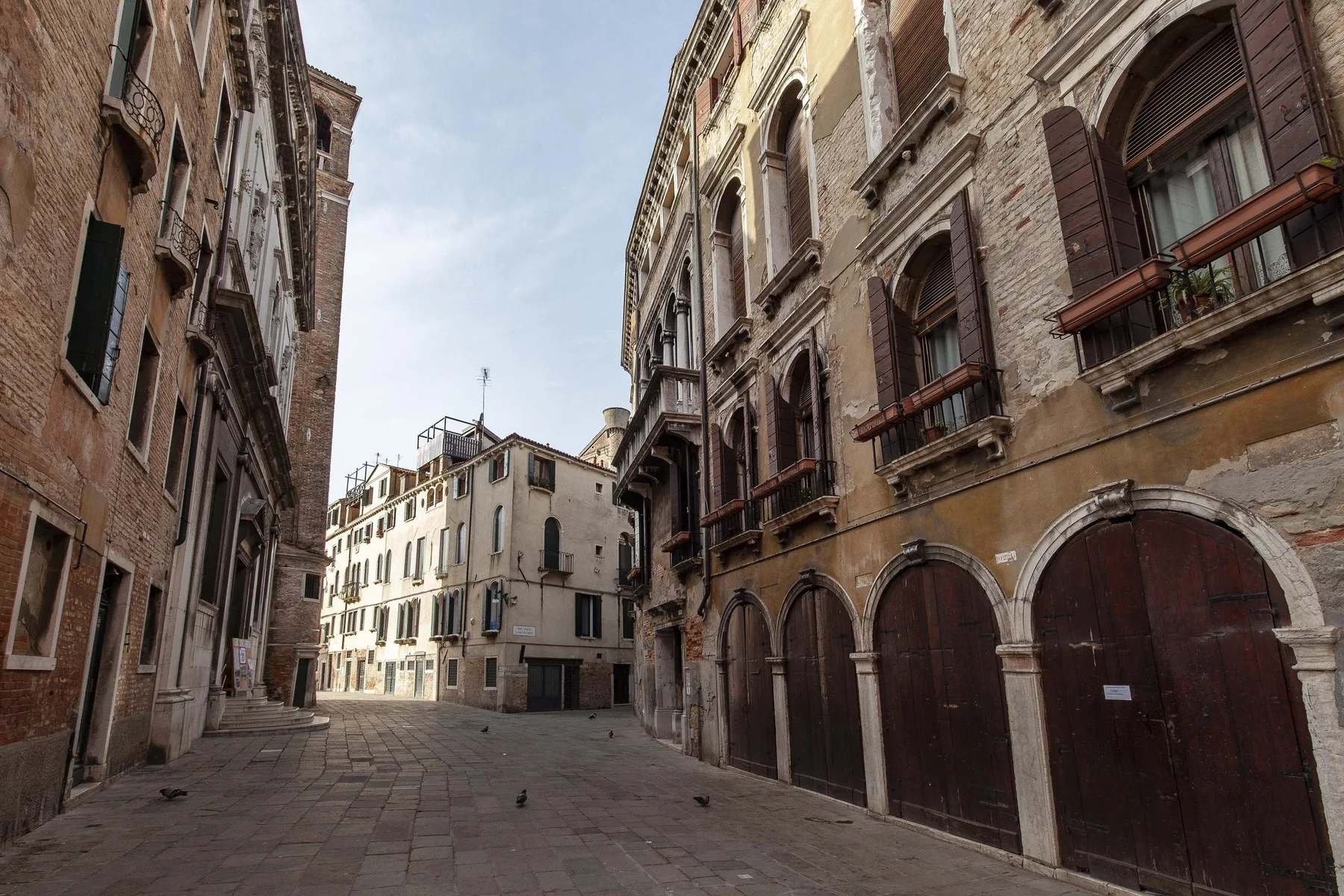 A narrow paved street runs between rows of historic buildings.