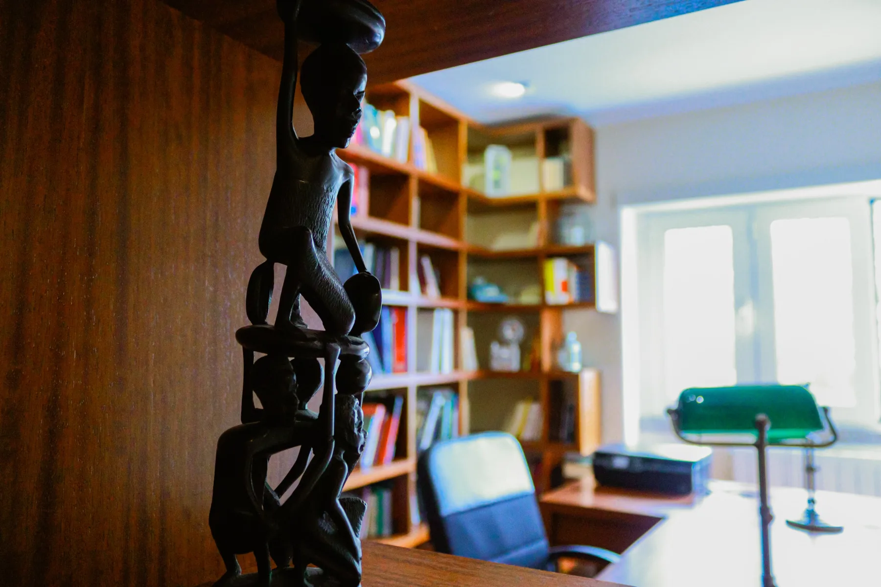A study with bookshelves and a desk by the window.