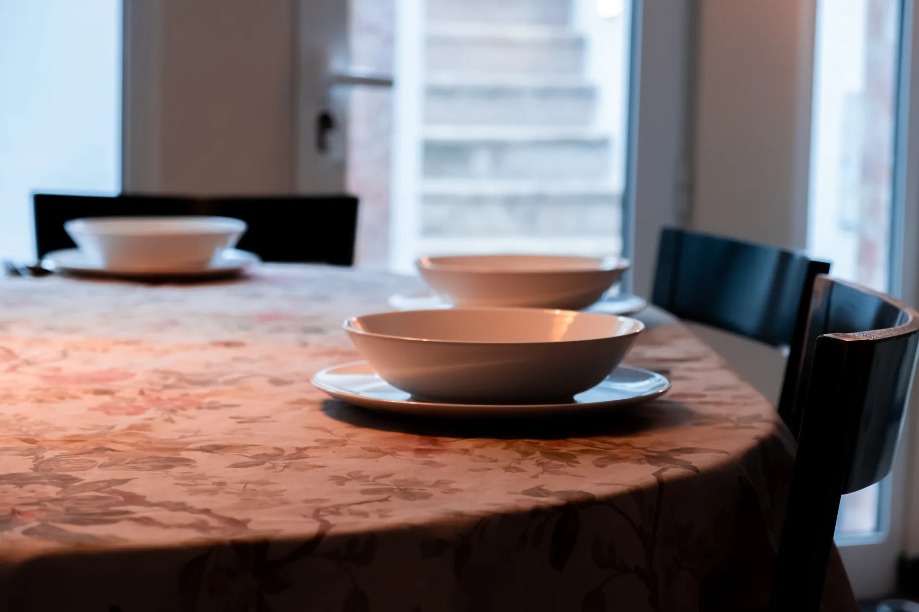 Dining area with a table set with bowls and surrounded by seating.