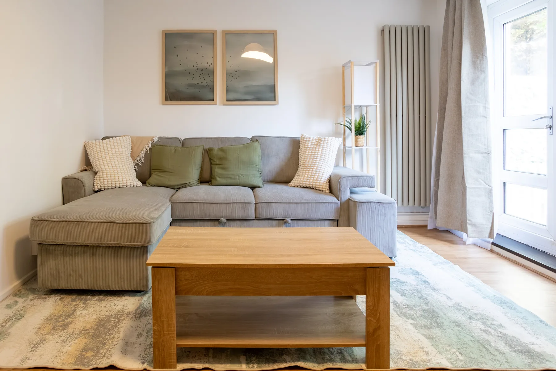 Living room with sectional seating, a wooden coffee table, and framed wall art.