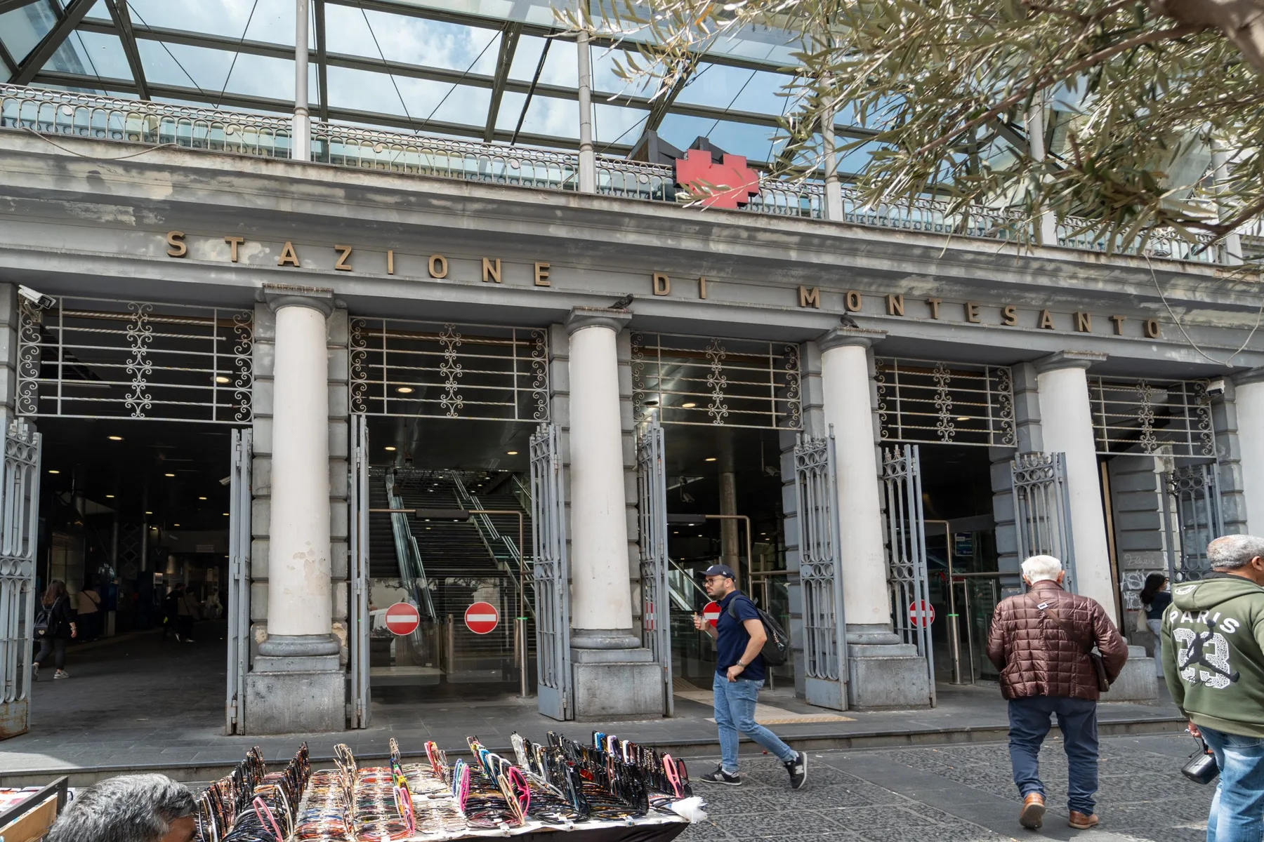 A covered market entrance with tall stone columns and glass doors.