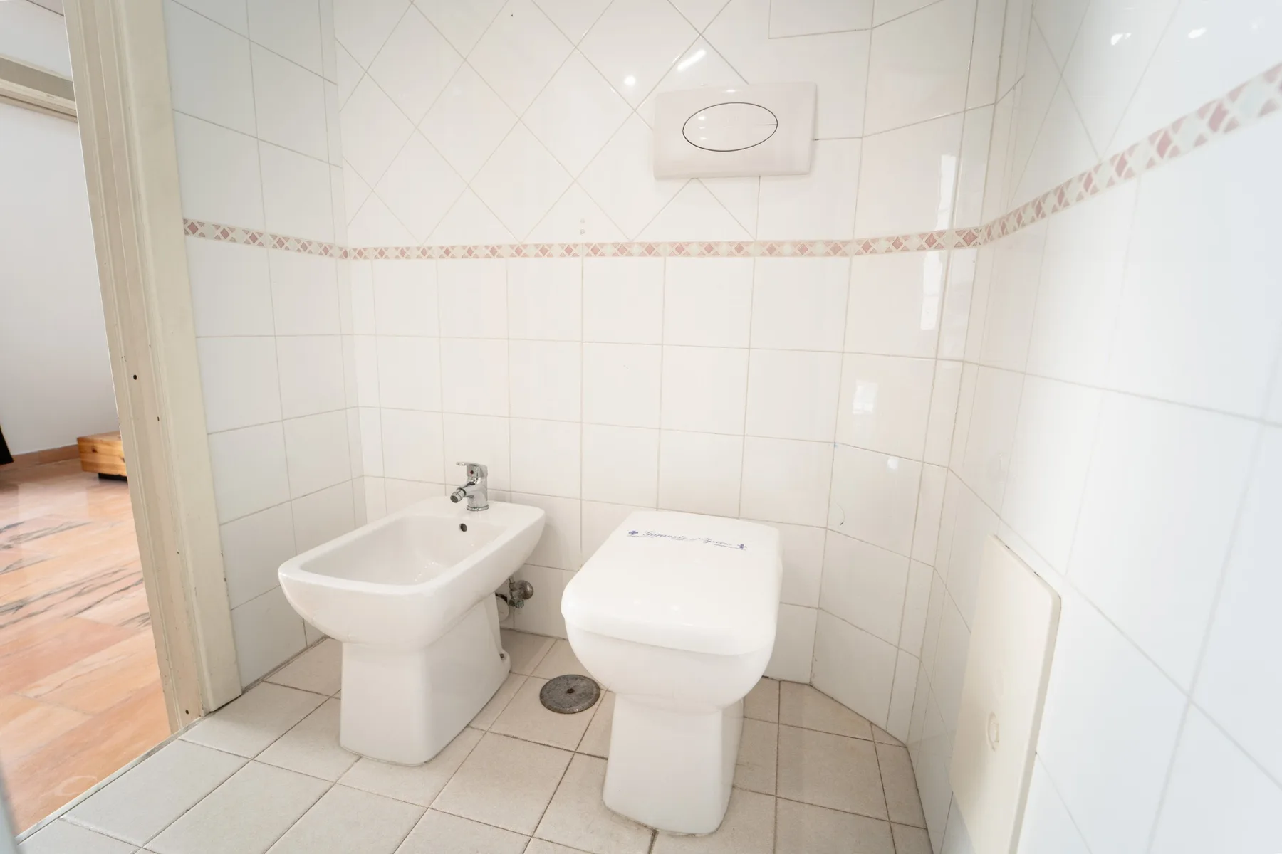 A tiled bathroom with a toilet and bidet.