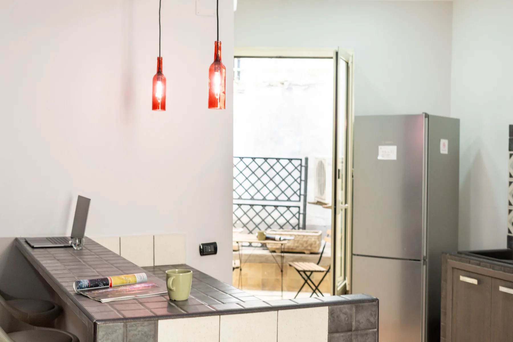 A bright kitchen counter opens onto a small outdoor seating area.