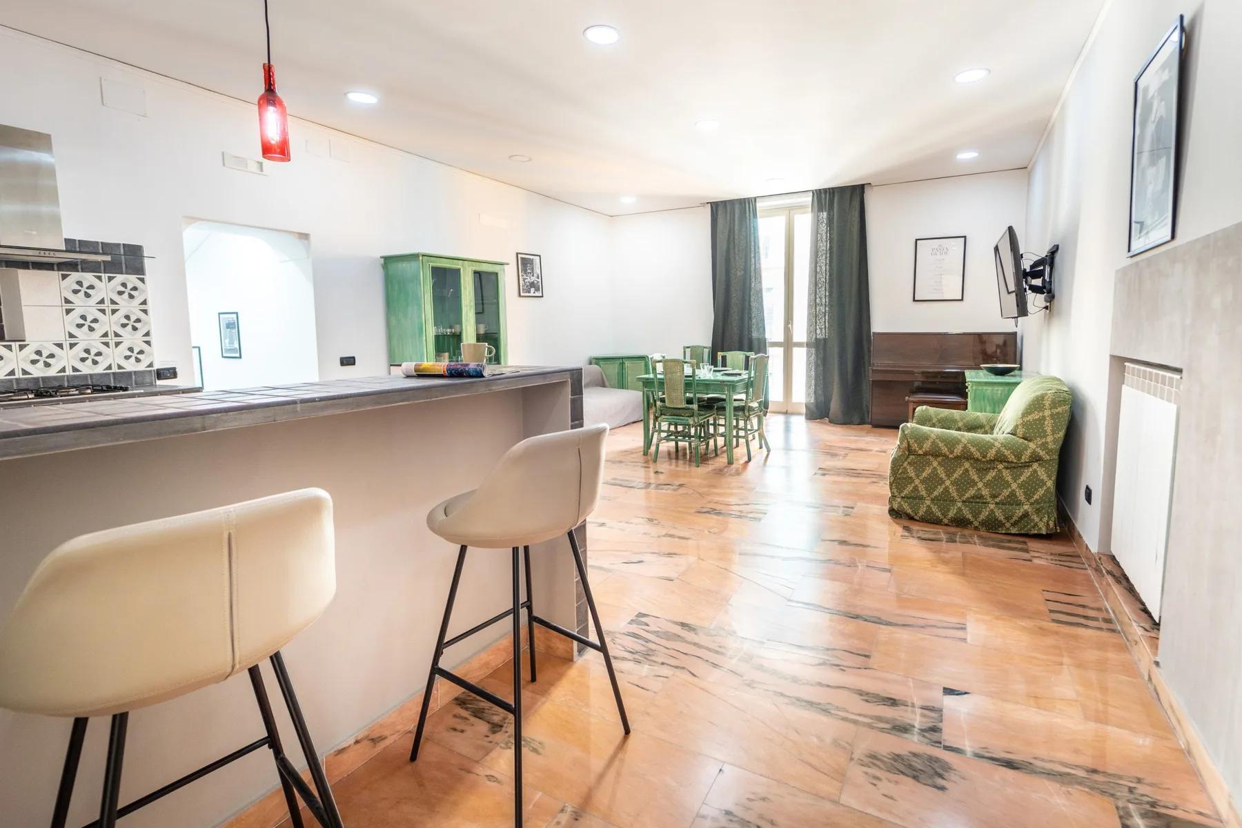 A bright open-plan living and dining area with a kitchen counter and table.