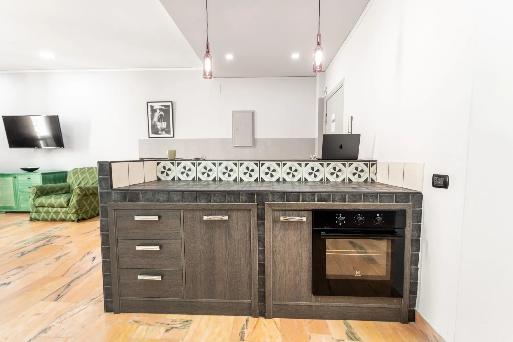 A kitchen counter with dark cabinets and a built-in oven.