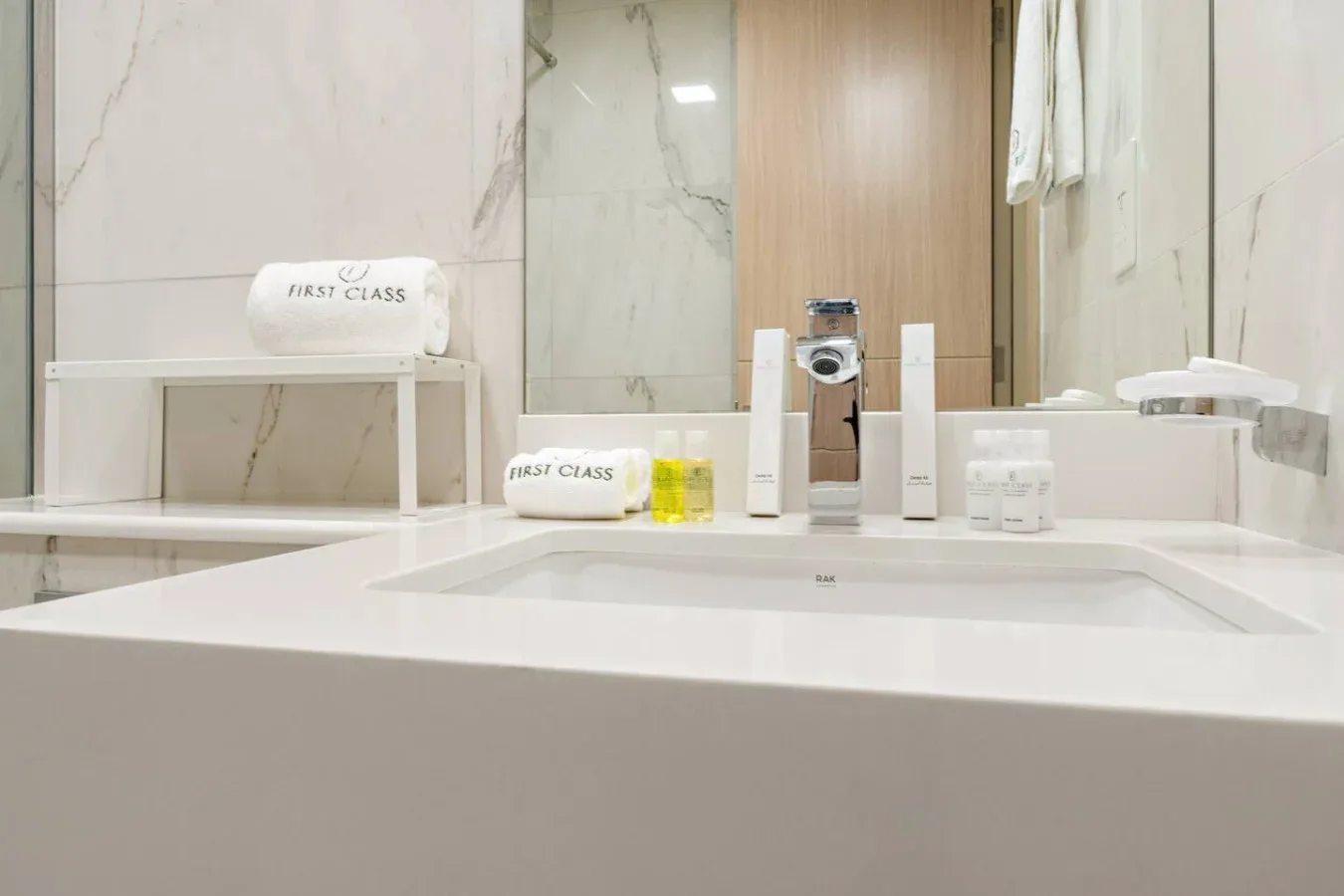Un tocador de baño con lavabo, artículos de aseo y espejo.