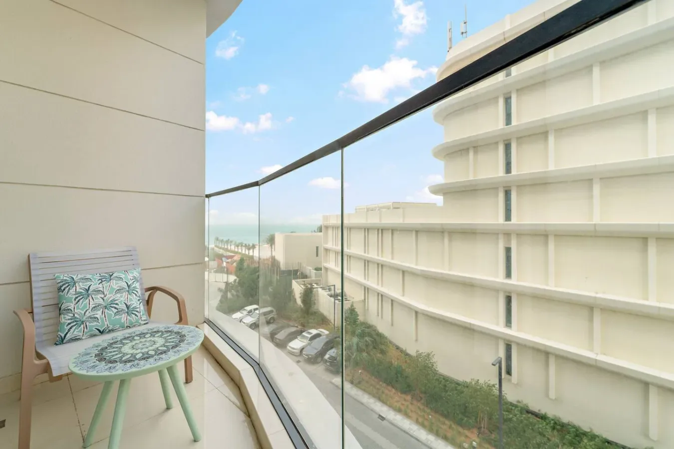 Una zona de estar en el balcón tiene vistas a edificios cercanos y la costa.