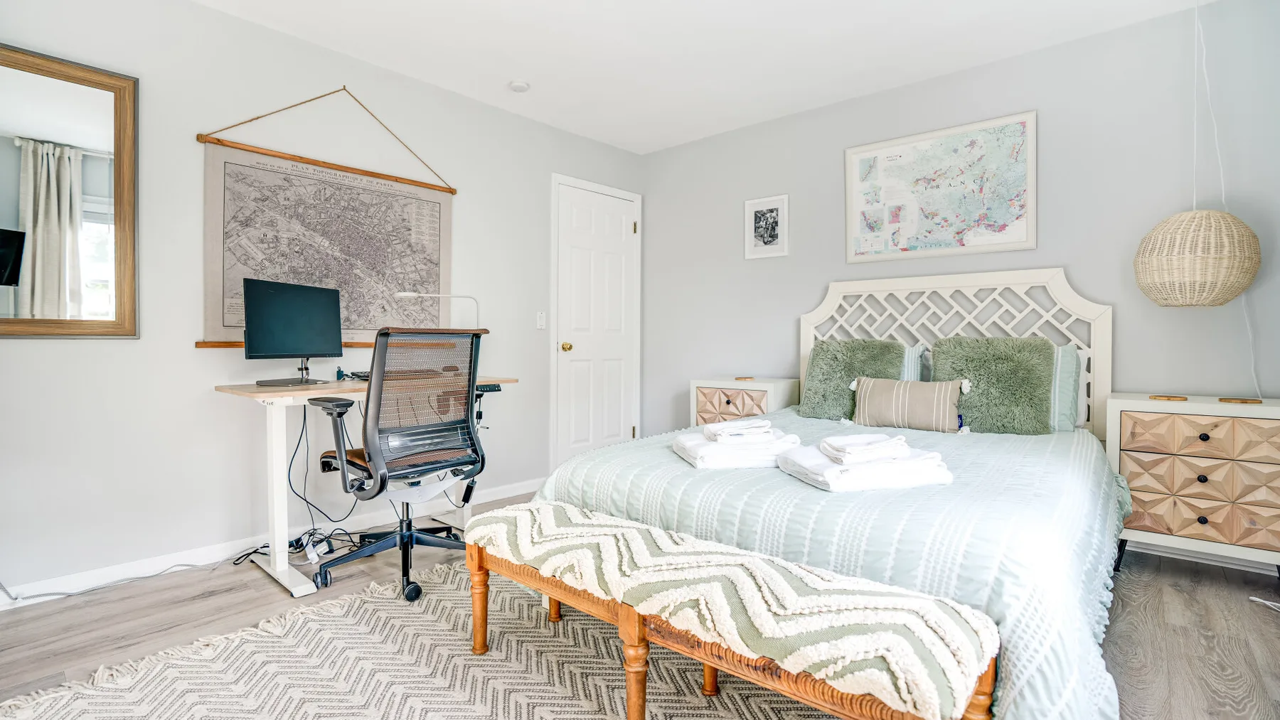Un dormitorio luminoso con una cama y un escritorio junto a la pared.