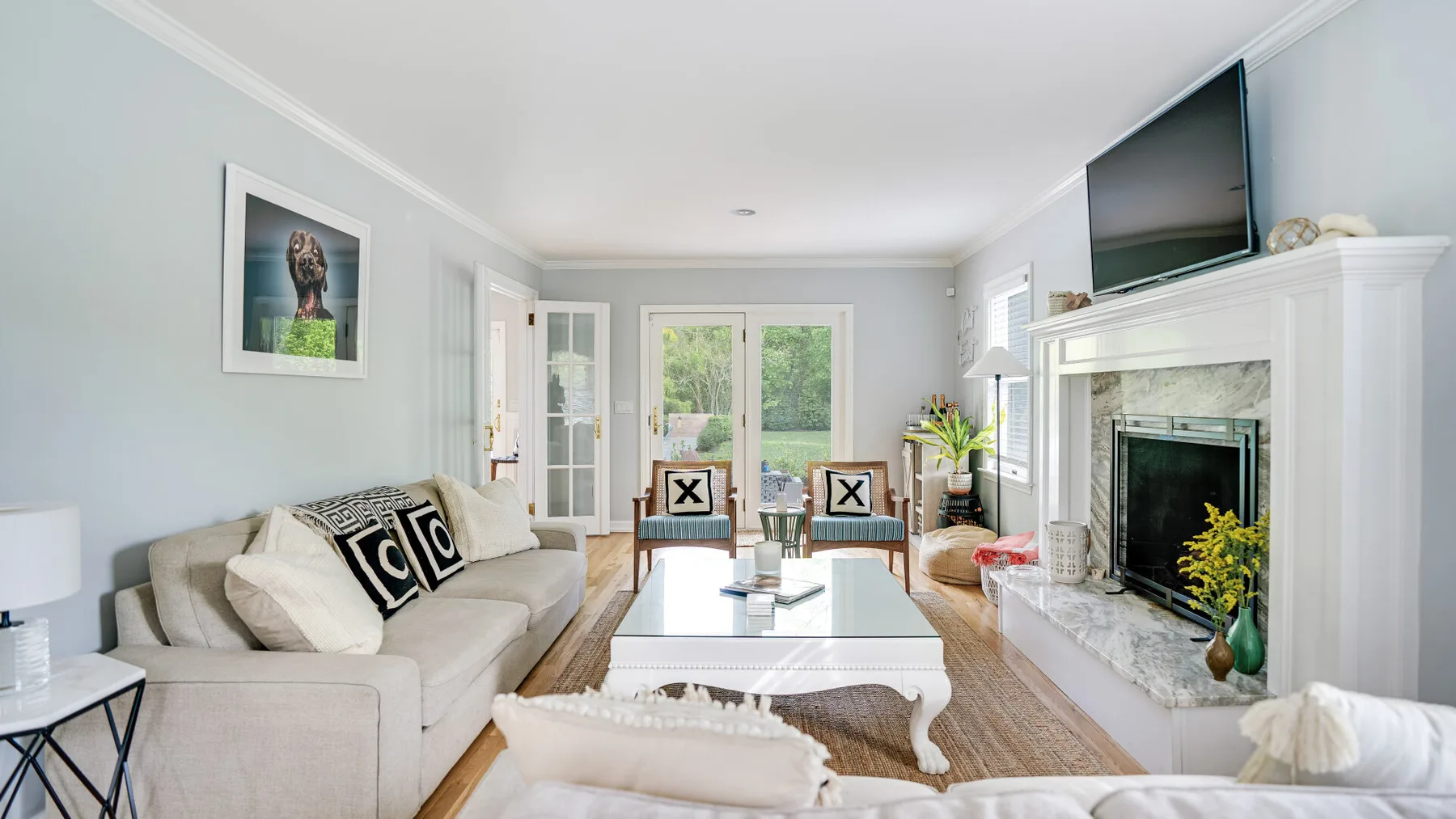 A bright living room with seating, a coffee table, and a fireplace.