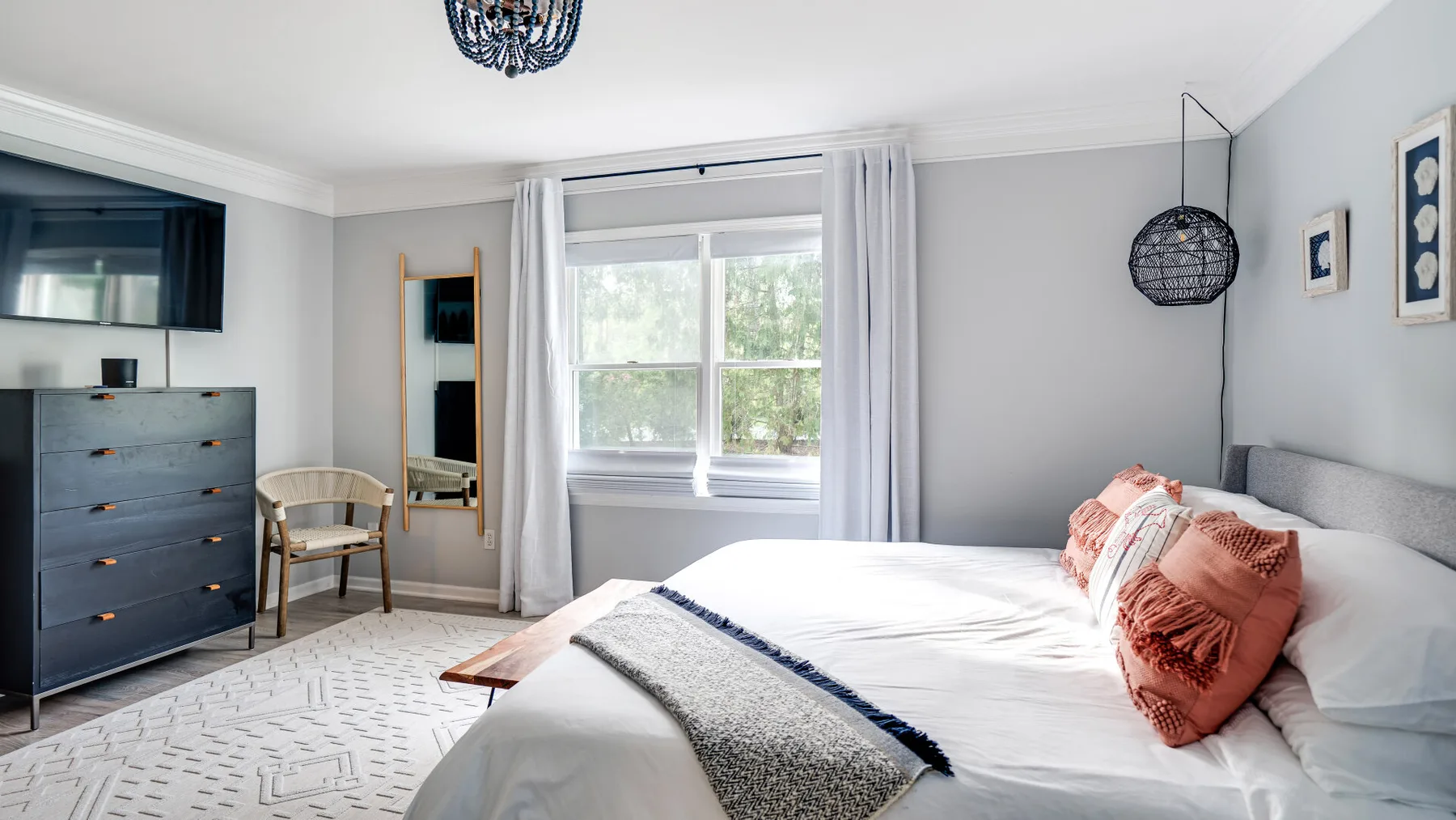 Un dormitorio luminoso con una cama grande junto a una ventana soleada.