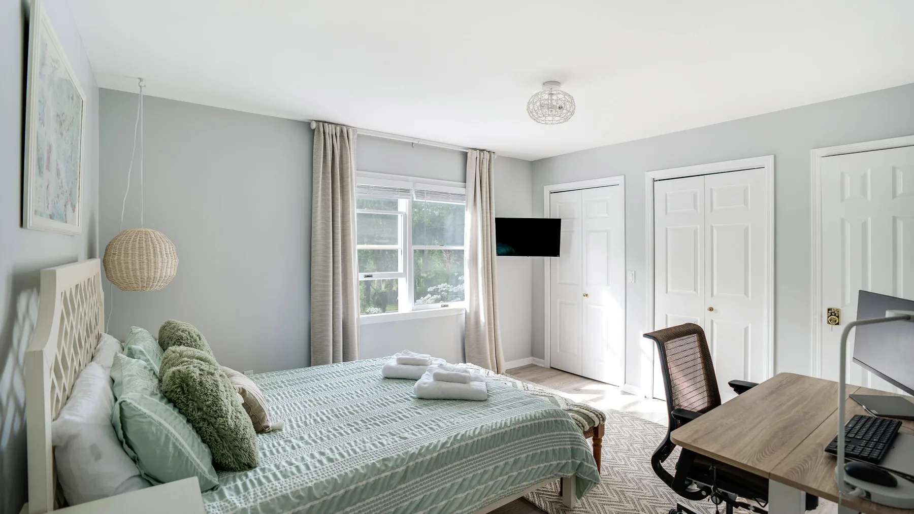 Un dormitorio con una cama junto a un escritorio y una silla.